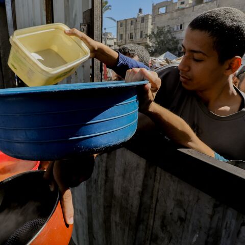 Children reach out with bowls, hoping to receive food during a distribution in Gaza City, with the population facing increasing hunger due to closed crossings. Oct. 21, 2024.