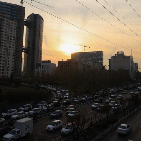 Traffic flows on a main road past electricity transmission towers in Tehran, on Dec. 16, 2024.