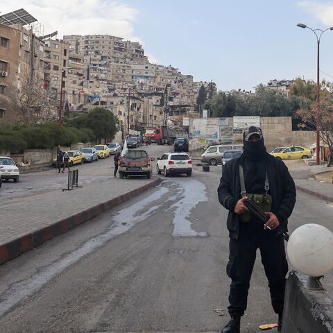 Fighters affiliated with Syria's new administration are deployed after closing a road leading to the Alawite-majority Mazzeh 86 neighbourhood in western Damascus, on Dec. 26, 2024.