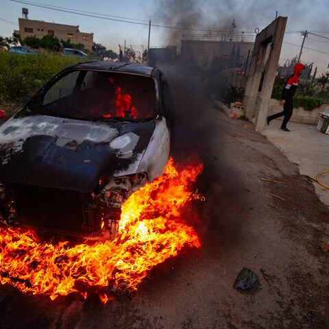 A car belonging to Palestinian villagers set on fire during clashes after the Israeli settlers stormed the village of Qusra in the Israeli-occupied West Bank on Saturday, April 13, 2024. (Photo by Wahaj Bani Moufleh / Middle East Images / Middle East Images via AFP) (Photo by WAHAJ BANI MOUFLEH/Middle East Images/AFP via Getty Images)