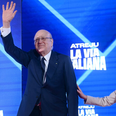 TOPSHOT - Lebanon's caretaker Prime Minister Najib Mikati waves from the stage next to Italy's Prime Minister Giorgia Meloni during the Atreju political meeting organised by the young militants of Italian right wing party Brothers of Italy (Fratelli d'Italia) on December 14, 2024 in Rome. (Photo by Filippo MONTEFORTE / AFP) (Photo by FILIPPO MONTEFORTE/AFP via Getty Images)