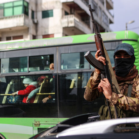 A fighter affiliated with Syria's new administration gestures with his rifle in Syria's western coastal city of Latakia on December 26, 2024. Syria's new authorities launched an operation in a stronghold of ousted president Bashar al-Assad on December 26, with a war monitor saying three gunmen affiliated with the former government were killed, a day after angry protests erupted in several areas around Syria over a video showing an attack on an Alawite shrine that circulated online. (Photo by AAREF WATAD / A