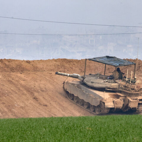 This picture taken from the Israeli side of the border with the Gaza Strip shows an Israeli army tank stationed on a hill overlooking northern Gaza on January 16, 2025, following the announcement of a truce amid the ongoing war between Israel and Hamas. Israel's cabinet was expected to meet on January 16, to approve a ceasefire and hostage-release deal with Hamas, Israeli media reported, a day after mediators announced an agreement they hope will lead to a permanent end to the Gaza war. (Photo by Menahem KA