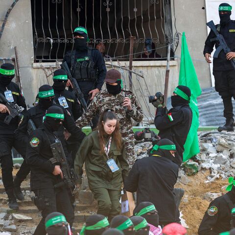 Hamas militants escort Isreali hostage Agam Berger (C) before handing her over to a Red Cross team in Jabalia on January 30, 2025