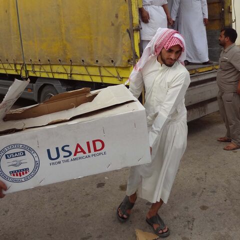 Iraqi men unload humanitarian aid supplies provided by USAID to displaced Iraqis who have fled clashes between Islamic State group jihadists and Peshmerga fighters on Oct. 2, 2014, in the town of Daquq.