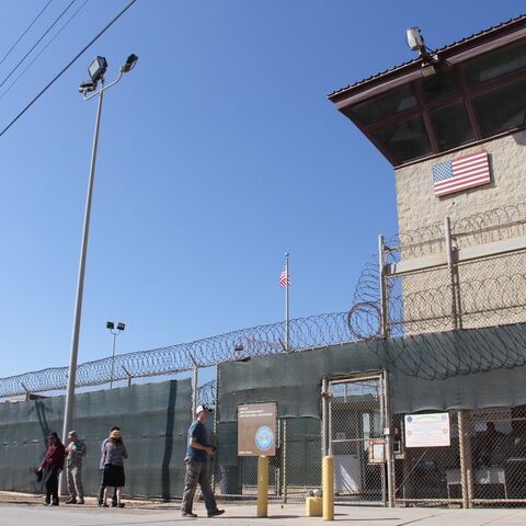 People walk past a guard tower outside the fencing of Camp 5 at the US Military's Prison in Guantanamo Bay, Cuba, on Jan, 26, 2017. 