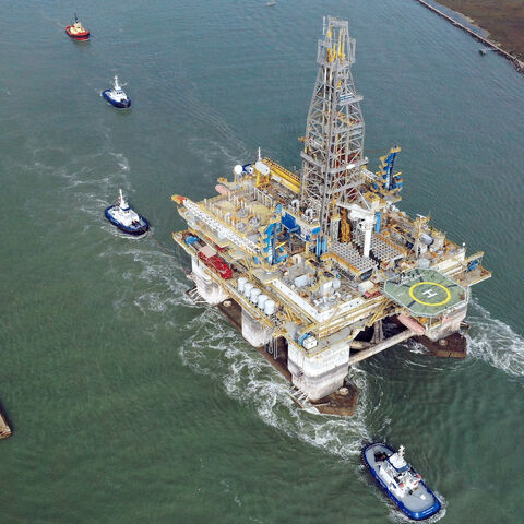 In this aerial image from a drone, tug boats tow the semi-submersible drilling platform Noble Danny Adkins through the Port Aransas Channel into the Gulf of Mexico on Dec. 12, 2020 in Port Aransas, Texas.