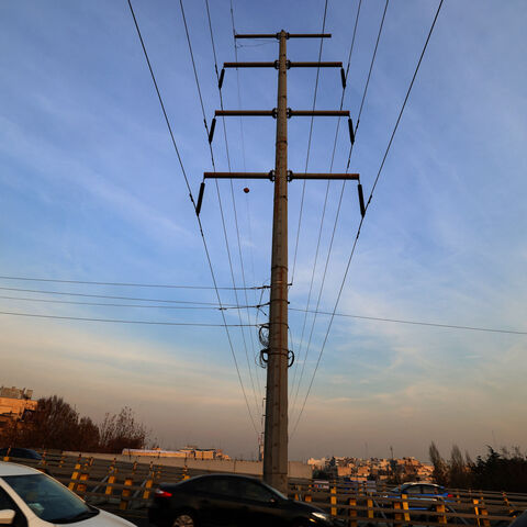 Traffic flows on a main road past electricity transmission towers in Tehran on December 16, 2024. Iran has suspended operations at several power plants over fuel shortages that have been intensified by rising demand during a spell of freezing weather. (Photo by ATTA KENARE / AFP) (Photo by ATTA KENARE/AFP via Getty Images)