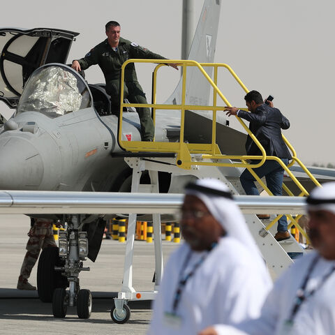 Emiratis walk past a French Rafale fighter jet displayed during the Dubai Airshow on November 14, 2017, in the United Arab Emirates. / AFP PHOTO / KARIM SAHIB (Photo credit should read KARIM SAHIB/AFP via Getty Images)