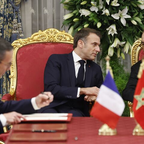 Morocco's king, Mohammed VI, speaks with France's president, Emmanuel Macron, as France's minister of the interior, Bruno Retailleau, and his counterpart from Morocco sign documents during their meeting in the Royal Palace in the capital, Rabat, on Oct. 28, 2024.