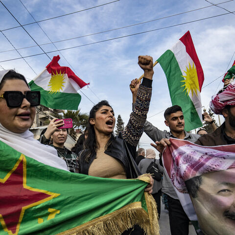 Syrian Kurds chant slogans and wave flags as they demonstrate in the northeastern city of Qamishli on March 14, 2025, against the new constitutional declaration announced by the interim government in Damascus the previous day.