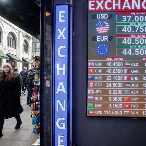 People walk past a currency exchange board showing the Turkish Lira which fell to historic lows against the dollar after the news of the arrest of Istanbul Mayor Ekrem Imamoglu on March 19, 2025 in Istanbul, Turkey.