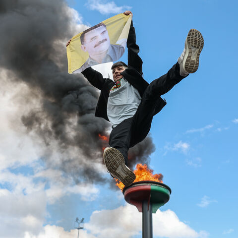DIYARBAKIR, TURKEY - MARCH 21: A young man jumps holding poster of the jailed PKK militant group leader Abdullah Ocalan during Newroz celebrations on March 21, 2025 in Diyarbakir, Turkey. Newroz, or Nowruz, a celebration of the spring equinox and Persian new year, is observed by a diverse array of communities across western and central Asia, including Kurdish areas of Turkey, Syria and Iraq. Newroz is the most important festival in Kurdish culture and has taken the form of political expression among Kurds i