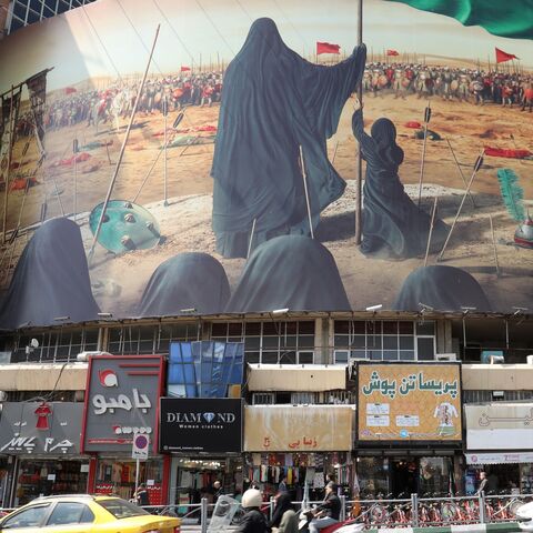 A picture taken on Sept. 7, 2019, shows traffic driving past a political mural at Vali Asr Square in the Iranian capital Tehran.