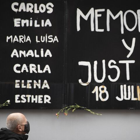 A man pays tribute during the commemoration of the 26th anniversary of a bomb attack