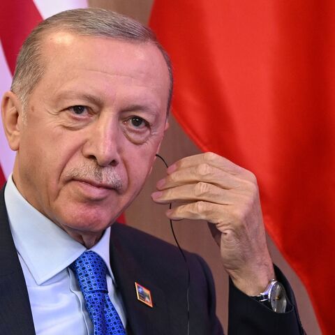 Turkey's President Recep Tayyip Erdogan looks adjusts his earpiece during bilateral talks with the US President the NATO Summit in Vilnius on July 11, 2023.
