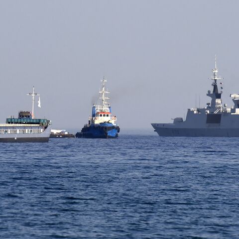 The barge Jennifer, part of a three ship flotilla carrying food aid for the Gaza Strip, sails next to the French frigate Courbet as the flotilla departs the port of Larnaca in Cyprus, March 30, 2024.