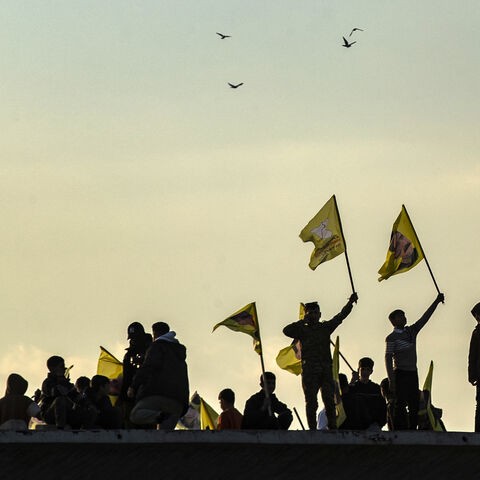Syrian Kurds wave flags bearing pictures of the founder of the Kurdistan Workers' Party (PKK) Abdullah Ocalan, as they gather in the Kurdish-majority city of Qamishli in northeastern Syria to listen to a message from the jailed leader on February 27, 2025. Ocalan issued a historic call on February 27 for his Kurdish militant force to disband and his fighters to lay down their arms. (Photo by Delil SOULEIMAN / AFP) (Photo by DELIL SOULEIMAN/AFP via Getty Images) SYRIA-TURKEY-CONFLICT-KURDS