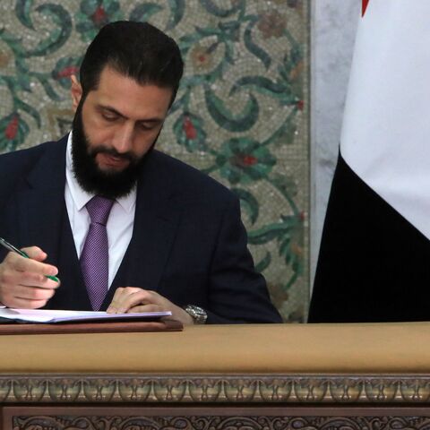 Syria's interim president, Ahmad al-Sharaa, signs the country's constitutional declaration, which will be enforced throughout a five-year transitional period, at the presidential palace in Damascus on March 13, 2025. 
