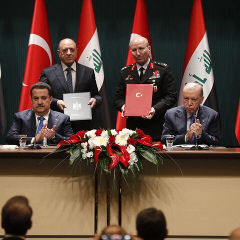 Turkish President Recep Tayyip Erdogan (front-R) and Iraqi Prime Minister Mohammed Shia al-Sudani (front-L) clap after sponsoring the signing ceremony of memoranda of understanding between Iraq and Turkey, in Ankara on May 8, 2025.