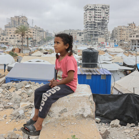 A Palestinian girl sits amid a makeshift displacement camp set up amid building rubble in Gaza City on May 12, 2025. Israeli Prime Minister Benjamin Netanyahu said on May 12 that the release of a US-Israeli hostage announced by Hamas would not lead to a ceasefire in the Gaza Strip or the release of Palestinian detainees. (Photo by Omar AL-QATTAA / AFP) (Photo by OMAR AL-QATTAA/AFP via Getty Images)