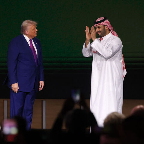 US President Donald Trump looks on as Saudi Crown Prince Mohammed bin Salman greets the crowd during the Saudi-US investment forum at the King Abdul Aziz International Conference Center in Riyadh on May 13, 2025. Saudi Arabia on May 13 promised billions of dollars in deals with the United States from defence to artificial intelligence as it threw a lavish welcome for President Donald Trump on the first state visit of his second term. (Photo by Fayez NURELDINE / AFP) (Photo by FAYEZ NURELDINE/AFP via Getty I