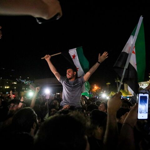 People celebrate in Damascus' Omeyyad square after US President Donald Trump's decision to lift sanctions in Syria, on May 13, 2025