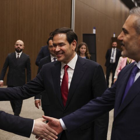 Turkish Foreign Minister Hakan Fidan (R) shakes hands with Syrian Foreign Minister Asaad Hassan al-Shaibani, and US Secretary of State Marco Rubio (C) reacts.