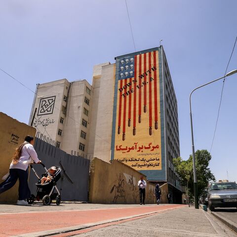 People walk near anti-US mural with the slogan "Down with the USA" and skulls replacing the stars on the flag, in Tehran, on May 20, 2025.