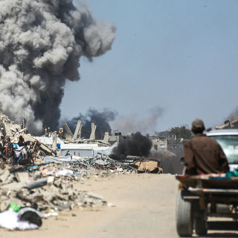 People watch as smoke billows following an Israeli strike in Jabalia, in the northern Gaza Strip on May 25, 2025. 