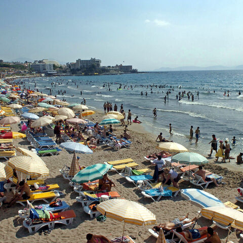 People enjoy the sun and the sea along the Kadinlar Beach of Kusadasi on July 17, 2005.