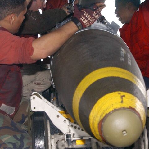 Aviation Ordnancemen assigned to "The Swordsmen" of Fighter Squadron Thirty Two (VF-32) transfer 2,000-pound Joint Directional Attack Munition (JDAMs).