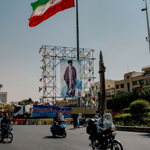 Iranian motorcyclist pass by a banner of Iran's Supreme Leader Ayatollah Ali Khamenei, placed next to a ballistic missile in Baharestan Square in Tehran, Iran, on September 26, 2024 on the sideline of an exhibition which marks the 44th anniversary of the start of Iran-Iraq war.