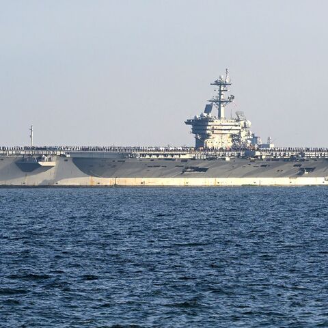 Members of the crew line the deck of the USS George Washington as the nuclear-powered aircraft carrier moves into Tokyo Bay to the US naval base at Yokosuka, Kanagawa prefecture, south of Tokyo, Nov. 22, 2024.