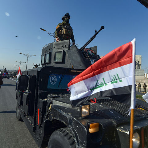 A military parade held by Iraq's army, Hashed al-Shaabi (Popular Mobilisation Forces), and the Police force drives on a highway during a ceremony marking the anniversary of the defeat of the Islamic State (IS) group, in the northern Iraqi city of Mosul on December 10, 2024. Iraq declared victory over fighters from the IS group at the end of 2017 after a three-year battle in which the jihadists had seized large swathes of the country. But jihadist cells still launch sporadic attacks against the army and poli