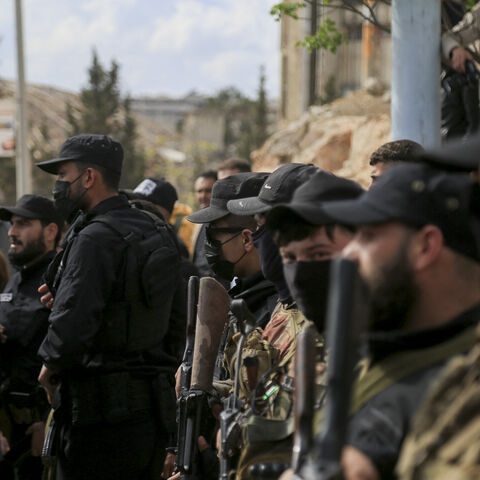 Armed personnel of SDF and public security forces of the new Syrian government stand guard as nearly a hundred prisoners are exchanged between the Kurdish-led Syrian Democratic Forces (SDF) and the new Syrian government in al-Ramun district of Aleppo, Syria, on April 3, 2025.
