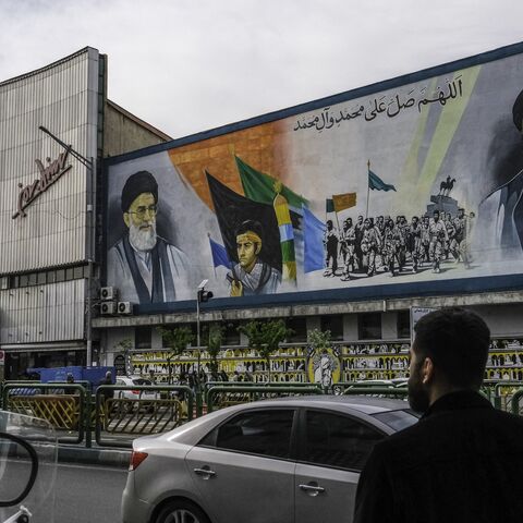 ranians pass by a mural that depicts the two Supreme Leaders of Iran near Enghelab (Revolution) Square in downtown Tehran, Iran on April 8, 2025.