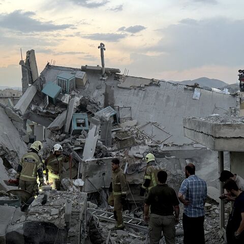 People and first-responders gather atop a building hit by an Israeli strike, Tehran, June 13, 2025.