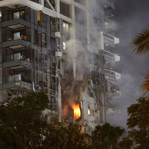 Fire and smoke rise from a building, reportedly hit by a missile fired from Iran, in central Tel Aviv on June 13, 2025.  