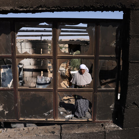 Palestinian Fawzya Ishreiteh clears burnt belongings in the living and kitchen area of her family house after a reported attack overnight by Israelis from a nearby settlement, in Susya south of Hebron city in the occupied West Bank on June 25, 2025. Israel has occupied the West Bank since 1967, and violence there has soared since the start of the Gaza war in 2023. The West Bank is home to about three million Palestinians, but also some 500,000 Israelis living in settlements that are illegal under internatio