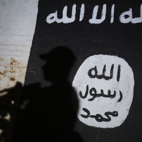 A member of the Iraqi forces walks past a mural bearing the logo of the Islamic State group in a tunnel that was reportedly used as a training center by the jihadists, on March 1, 2017, in the village of Albu Sayf, on the southern outskirts of Mosul.