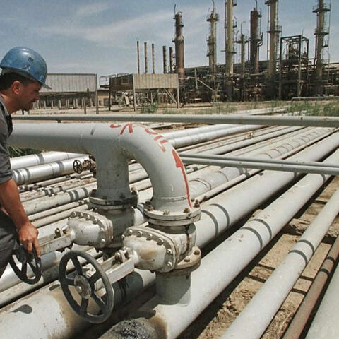 Iraqi workers tend to a pipe at the Iraqi-Turkish pipeline in Karkuk, northern Iraq, Dec. 1, 2000.