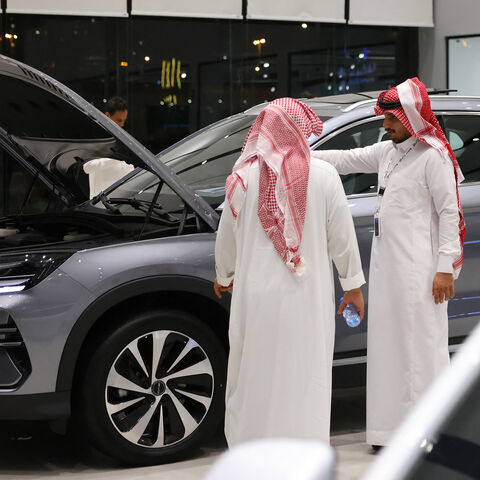 Men inspect an electric car at a showroom in Riyadh on June 8, 2024.