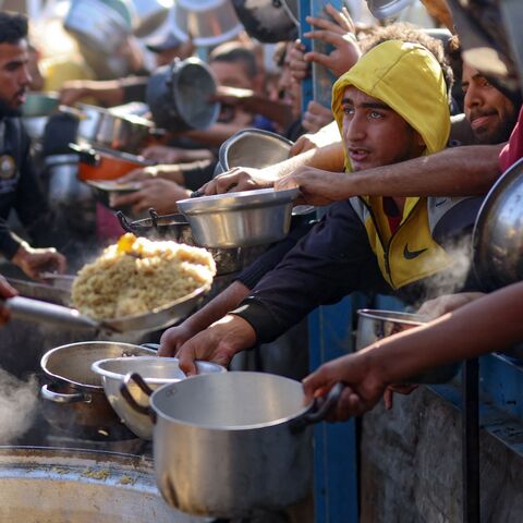 Palestinians wait in a queue to receive food outside a distribution center south of Khan Younis, on Dec. 6, 2024, amid the ongoing war between Israel and Hamas.
