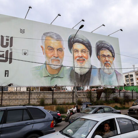 Traffic moves beneath a banner depicting the slain leader of the Lebanese Shiite Islamist movement Hezbollah Hassan Nasrallah (C) and his deputy Hashem Safieddine (C-R) as well as that of slain Iranian General Qassem Soleimani on Beirut Airport Road, in Beirut on February 19, 2025. The pro-Iran group has called for a huge turnout when Nasrallah, killed in a September Israeli strike, is laid to rest in the Lebanese capital on February 23. (Photo by ANWAR AMRO / AFP) (Photo by ANWAR AMRO/AFP via Getty Images)