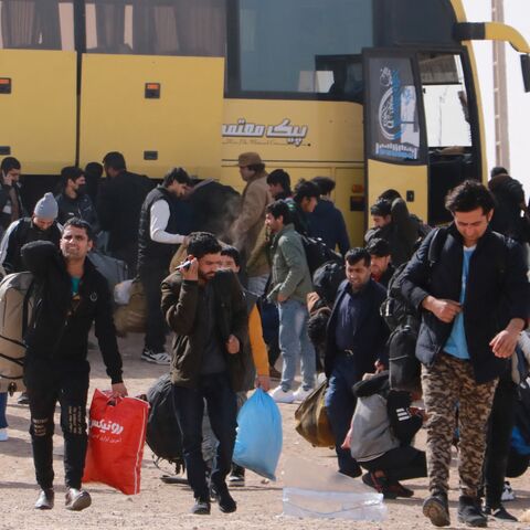 Afghan migrants who were living in Iran as refugees deboard a bus after being deported back to Afghanistan at the zero point between Afghanistan and Iran in the Herat province on Feb. 23, 2025. 