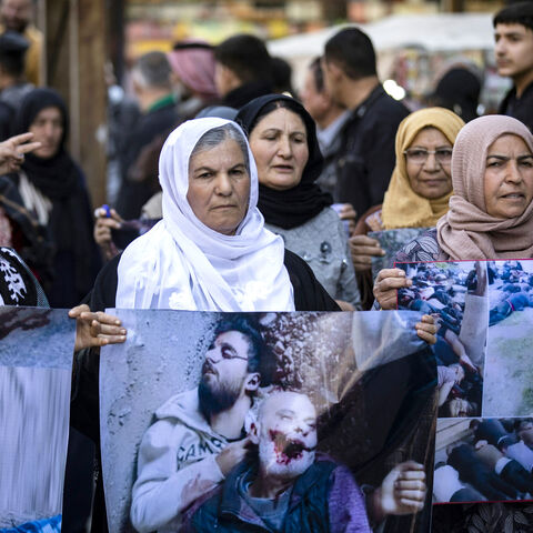 EDITORS NOTE: Graphic content / Women march with pictures of victims of a recent wave of sectarian violence targeting Syria's Alawite minority in the west of the country along the Mediterranean sea coast, during a protest condemning the attacks in Syria's northeastern city of Qamishli on March 11, 2025. (Photo by Delil SOULEIMAN / AFP) (Photo by DELIL SOULEIMAN/AFP via Getty Images)