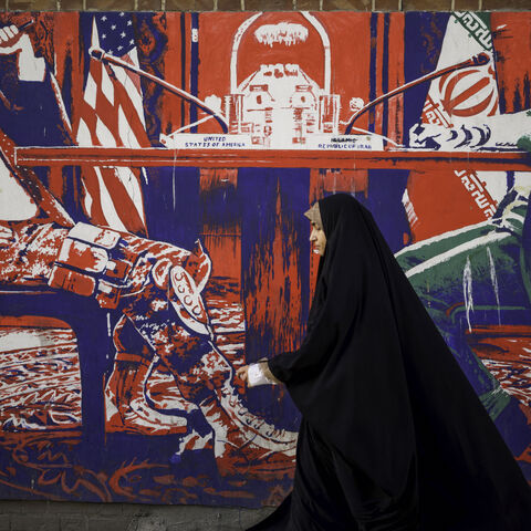 Iranians pass by the anti-American murals painted on the walls of the former embassy of the United States of America in Tehran, Iran on April 16, 2025, four days after Iran held the first round of indirect nuclear negotiations with President Trump's administration hosted and mediated by Oman. (Photo by Mohammadali Najib / Middle East Images / Middle East Images via AFP) (Photo by MOHAMMADALI NAJIB/Middle East Images/AFP via Getty Images)
