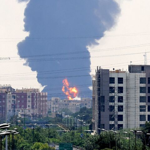 A plume of heavy smoke and fire rise from an oil refinery in southern Tehran after it was hit in an overnight Israeli strike, on June 15, 2025.