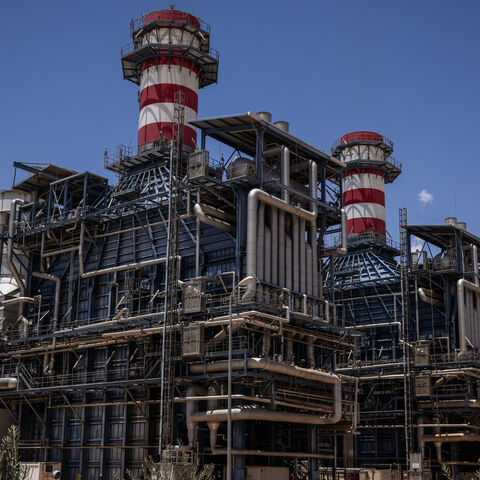 Workers walk past the gas turbine and heat recovery system of Syria's largest power plant on June 12, 2025 in Deir Ali, Syria. 
